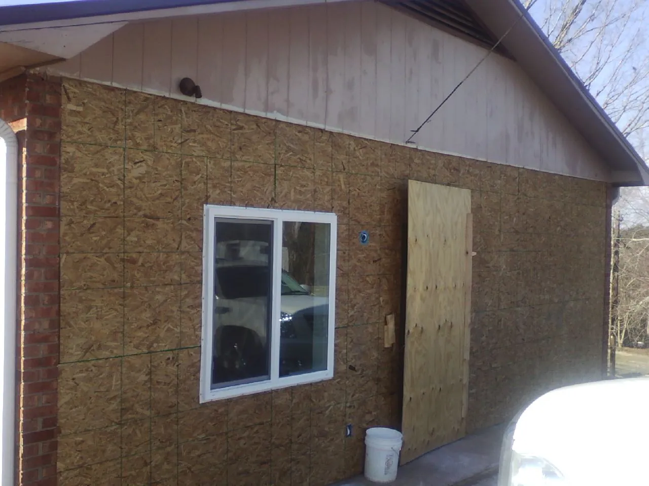 OSB sheathing on a garage addition wall before siding in Canfield