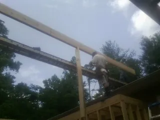 Carpenter setting a ridge beam over a new addition frame — Ice Dam Removal by Roofing Brothers in Canfield