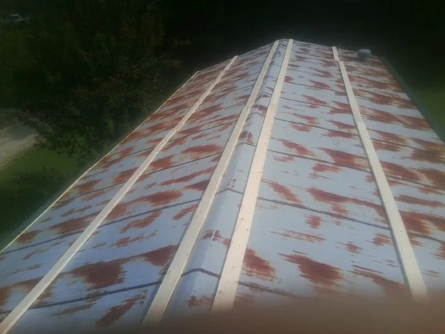 Rusted metal roof panels with new wood purlins before replacement — Storm Damage Roof Repair in Canfield by Roofing Brothers