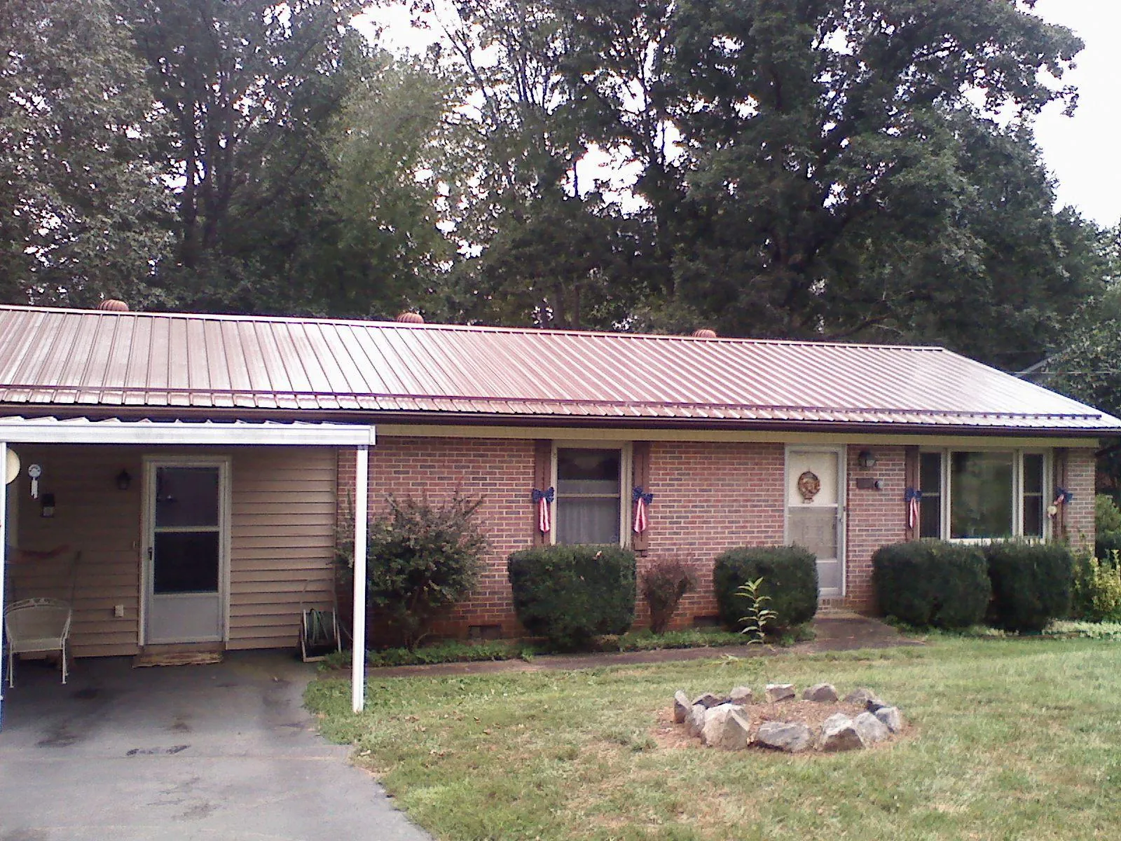 Bronze metal roof and carport on a brick ranch home — Roof Repair work by our crew in Canfield